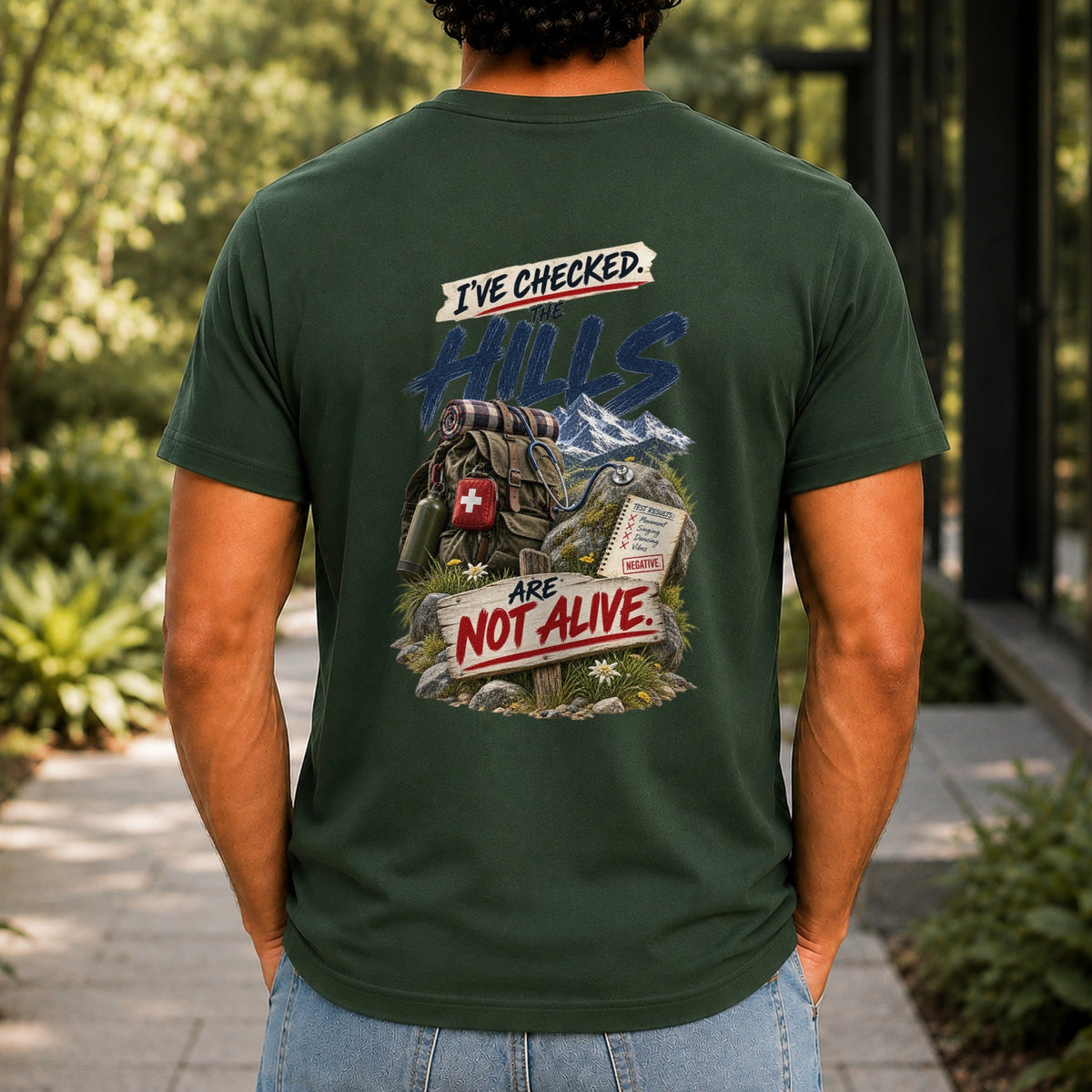 The Hills Are Not Alive graphic printed on the back of a forest green KRED Threads premium tee