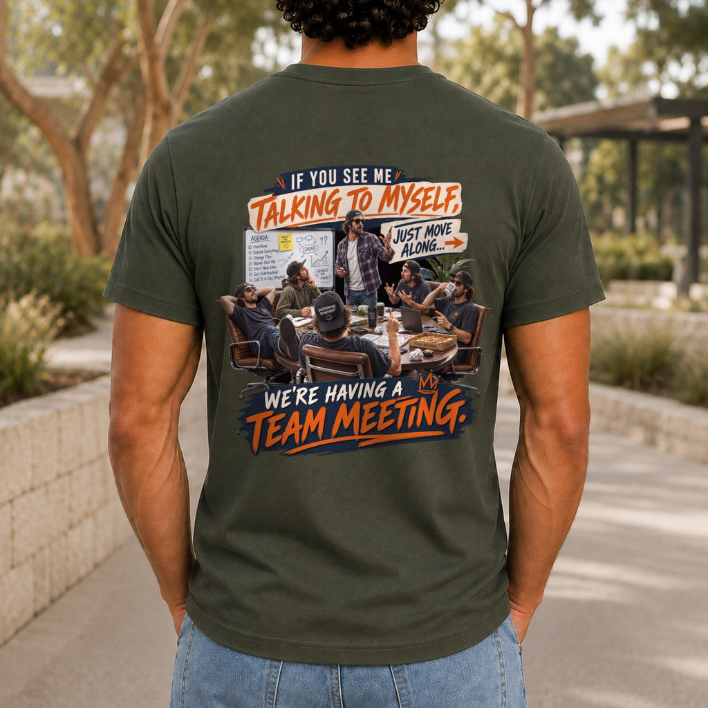 We're Having A Team Meeting graphic printed on the back of an army KRED Threads premium tee