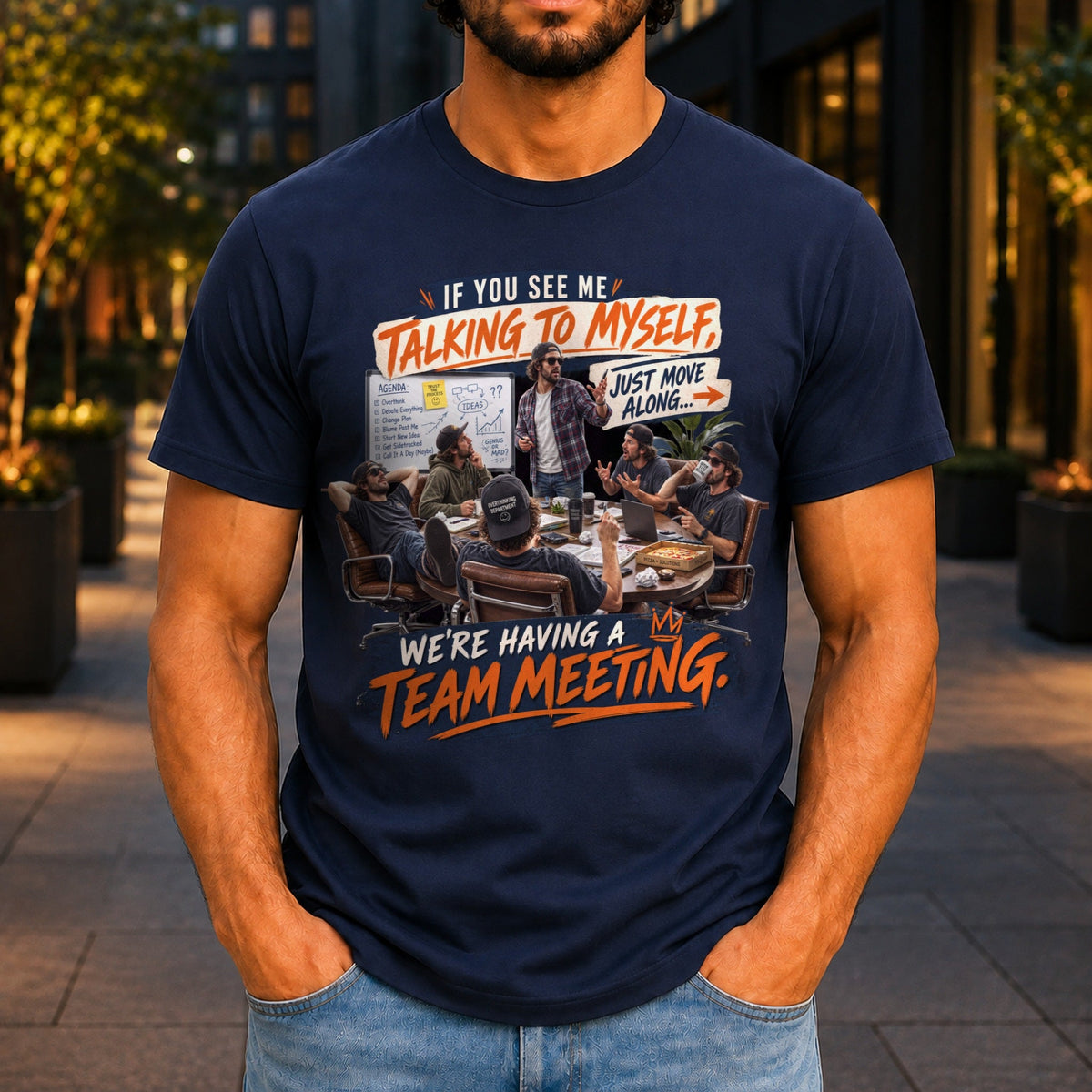 We're Having A Team Meeting graphic printed on the front of a navy KRED Threads premium tee