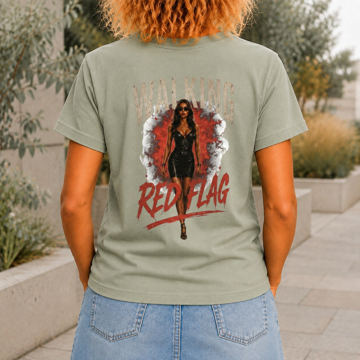 Walking Red Flag graphic printed on the back of a sage KRED Threads premium tee